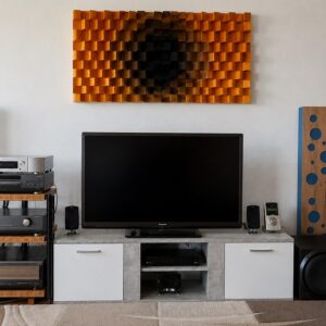 Panel con relieve junto a una zona TV, combinado con mueble bajo y luz indirecta cálida Panel con relieve junto a una zona TV, combinado con mueble bajo y luz indirecta cálida