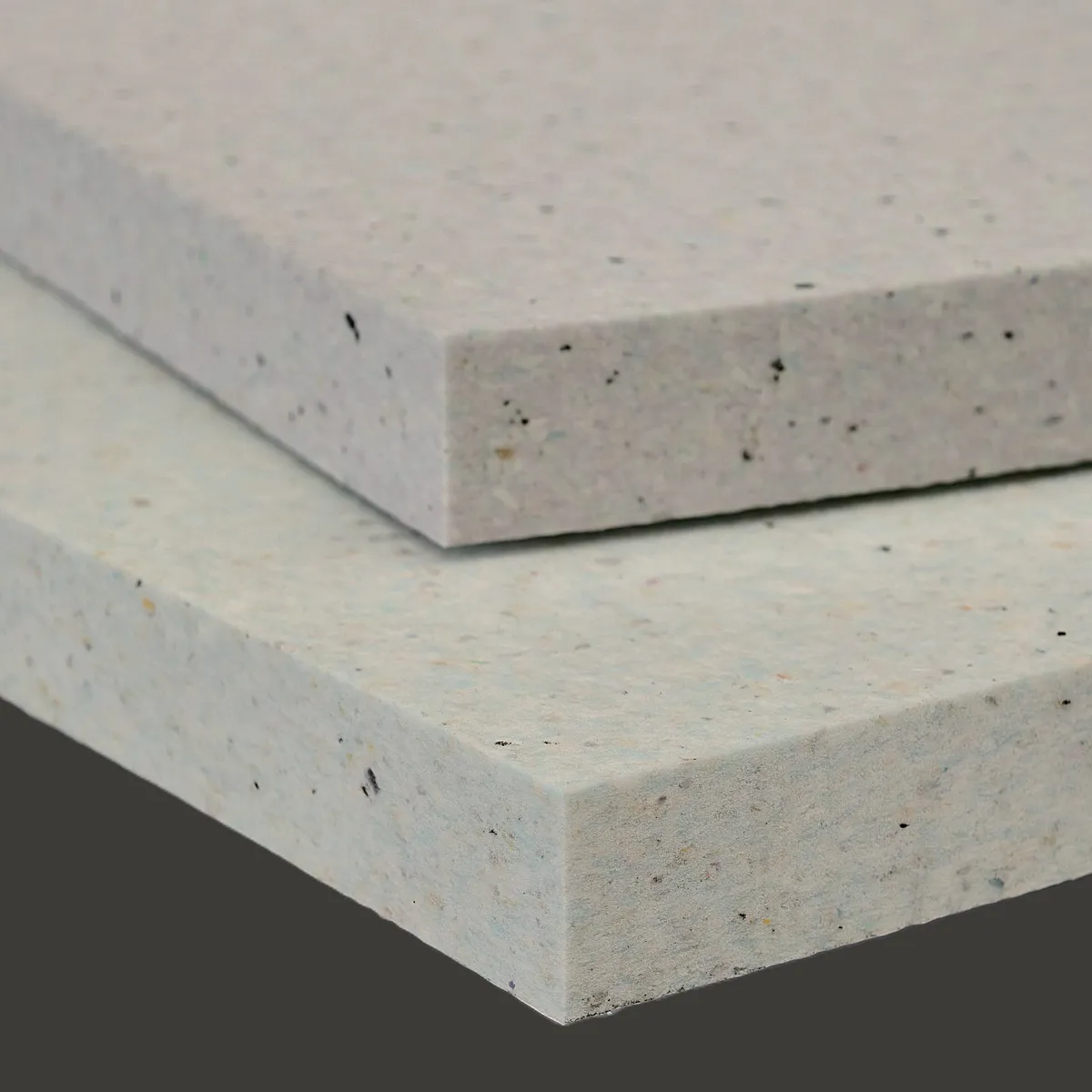 Detalle lateral de varias placas gruesas de esponja fonoabsorbente para tabiques, donde se aprecia claramente su elevada densidad, espesor y estructura compacta.