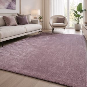 Alfombra Luxury Harmony 01RRR-1 en color malva colocada en un salón luminoso con sofá claro, sillón y detalles decorativos en tonos neutros.