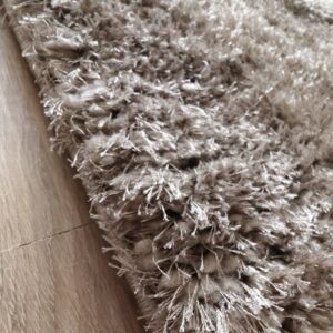 professional-calm-brown-alfombra-marron-detalle-fibras Primer plano de la alfombra Professional Calm Brown mostrando sus fibras largas, densas y ligeramente brillantes en tono marrón topo.